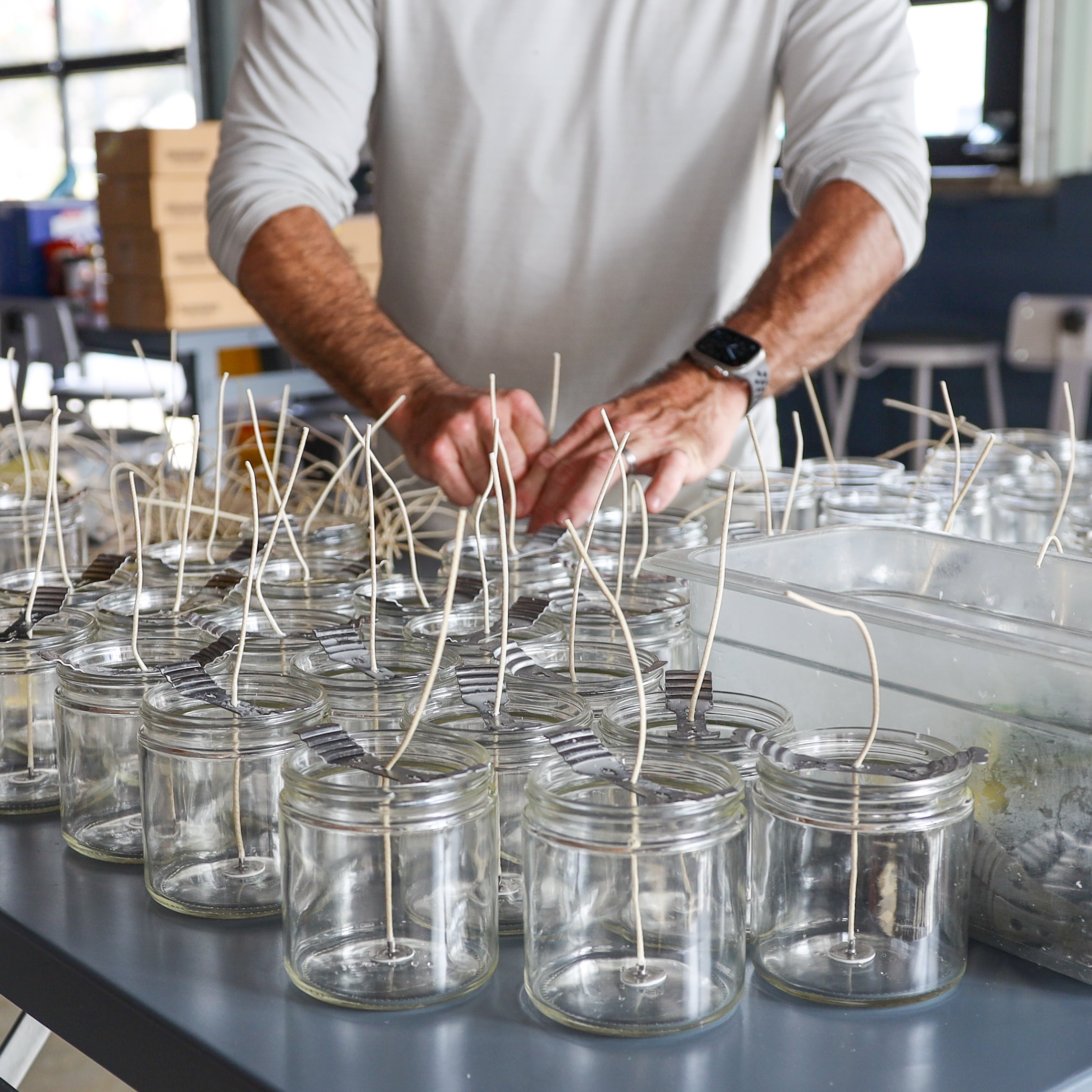 Seasonal Tallow & Beeswax Candle 16oz | Non Toxic Grass-Fed All-Natural Clean Burning - artisan placing wicks in glass jars for clean burning candles