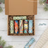 Open cardboard box with colorful items on a festive background with Christmas decorations.